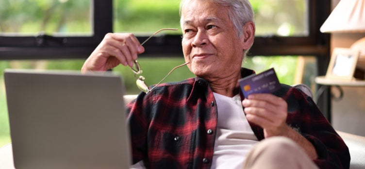 Senior man with credit card online shopping