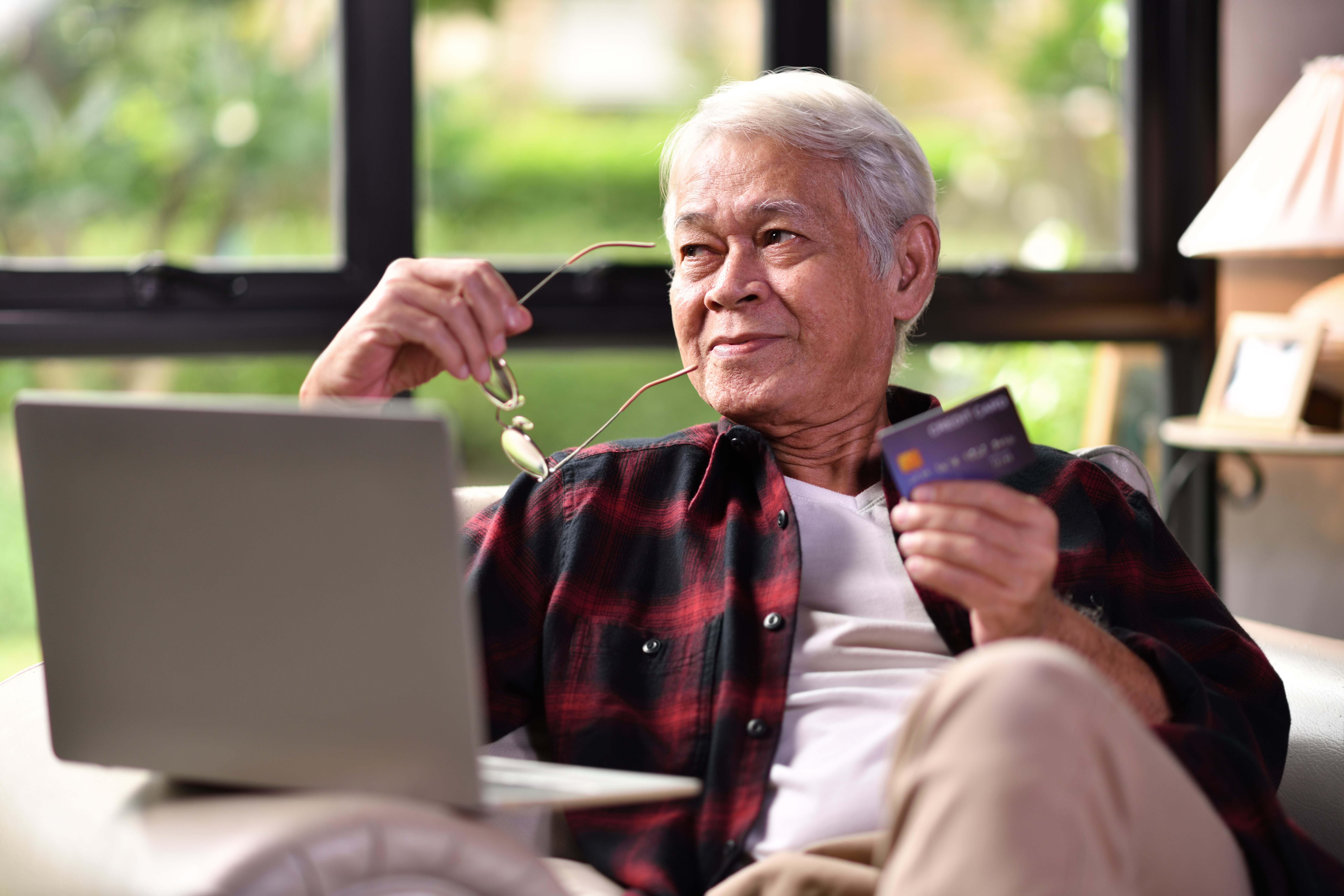 Senior man with credit card online shopping