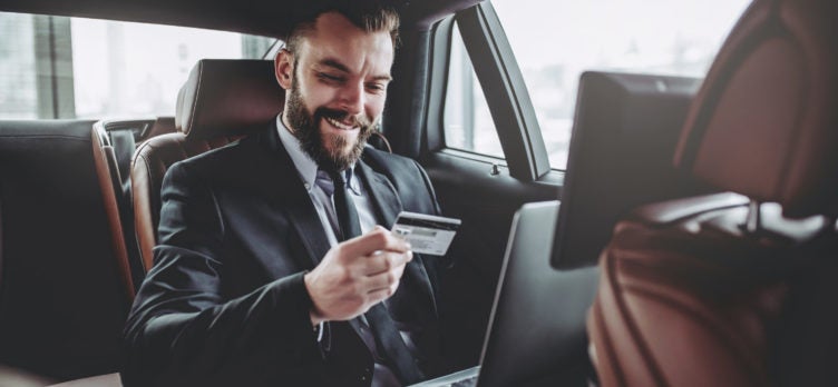 Businessman using credit card in car