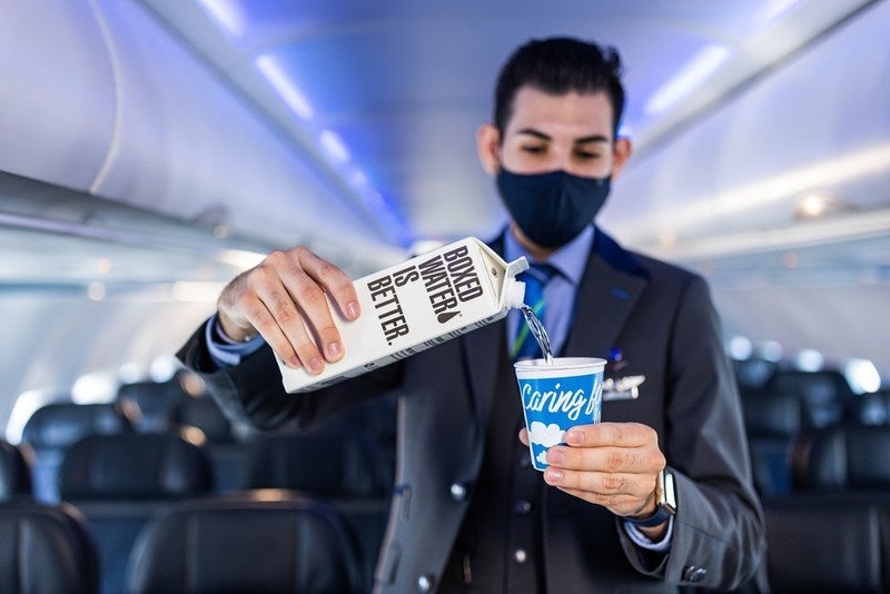 Alaska Airlines Crew Member Serves Boxed Water