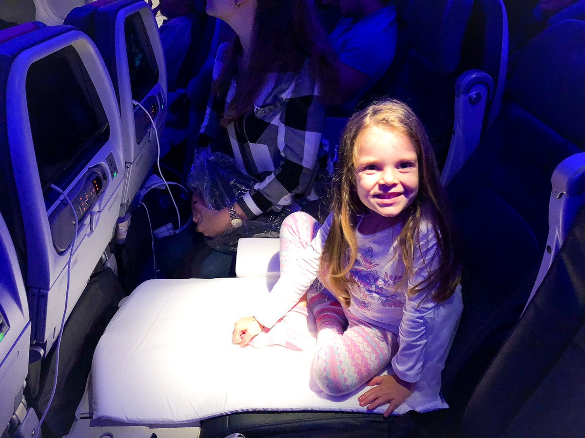 Girl using JetKids BedBox on a plane