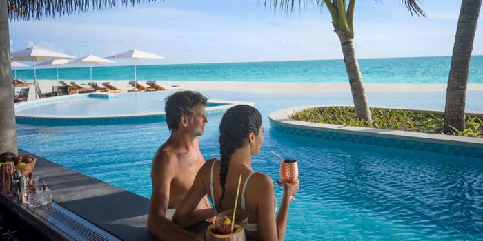 InterContinental Maldives Maamunagau Resort couple at pool InterContinental Maldives Maamunagau Resort couple at pool