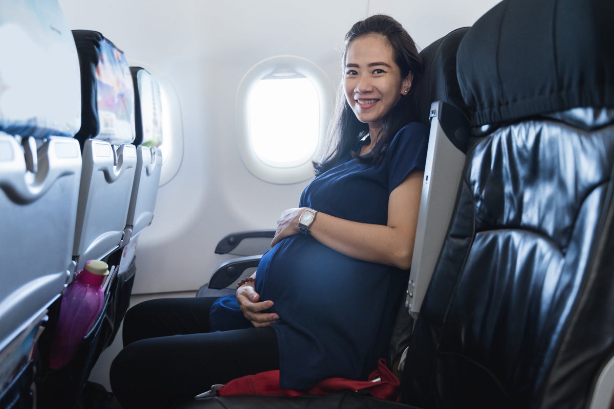 Smiling pregnant woman on plane