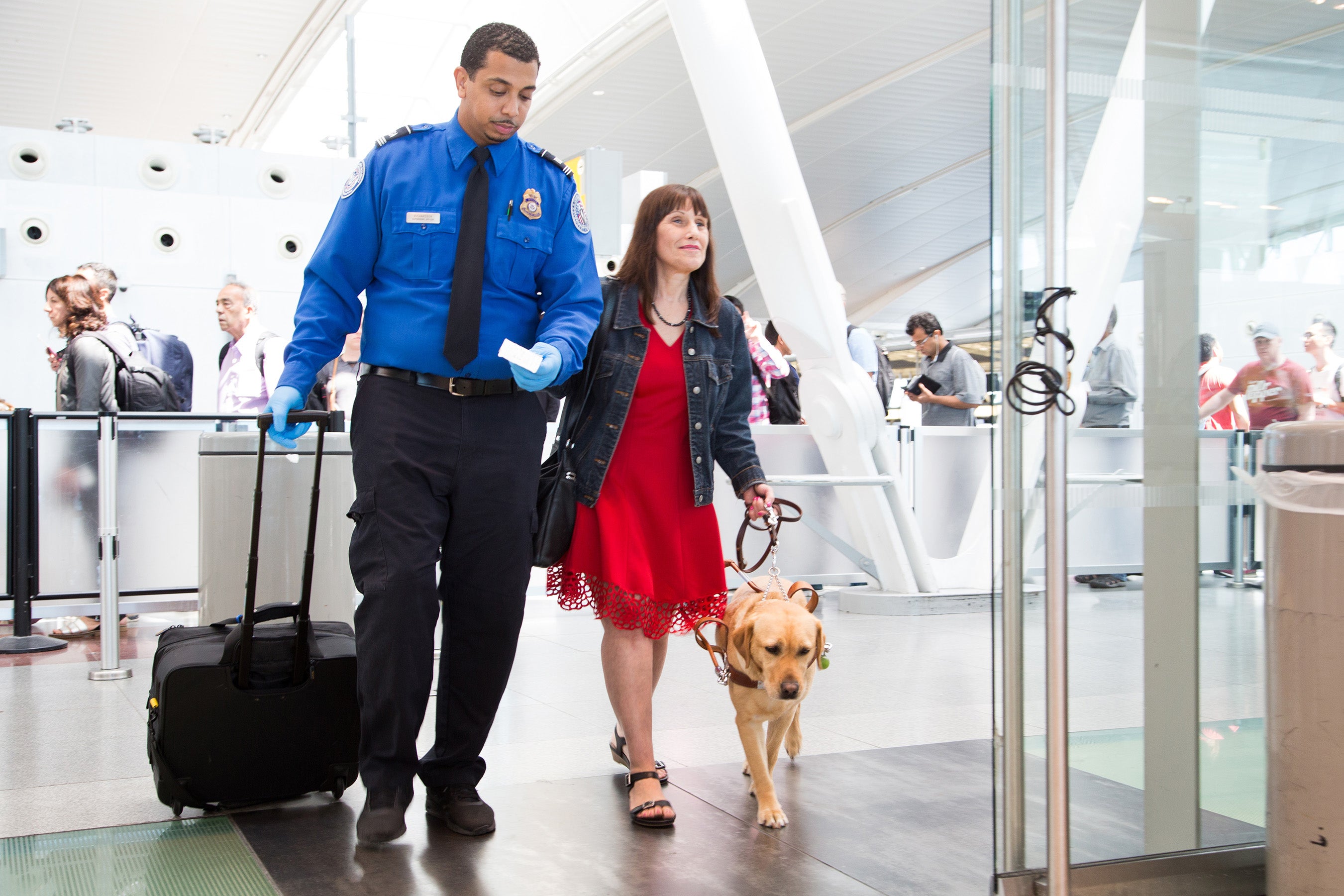 TSA agent and woman with guide dog at airport