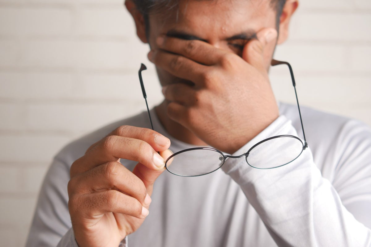 Frustrated man removing glasses