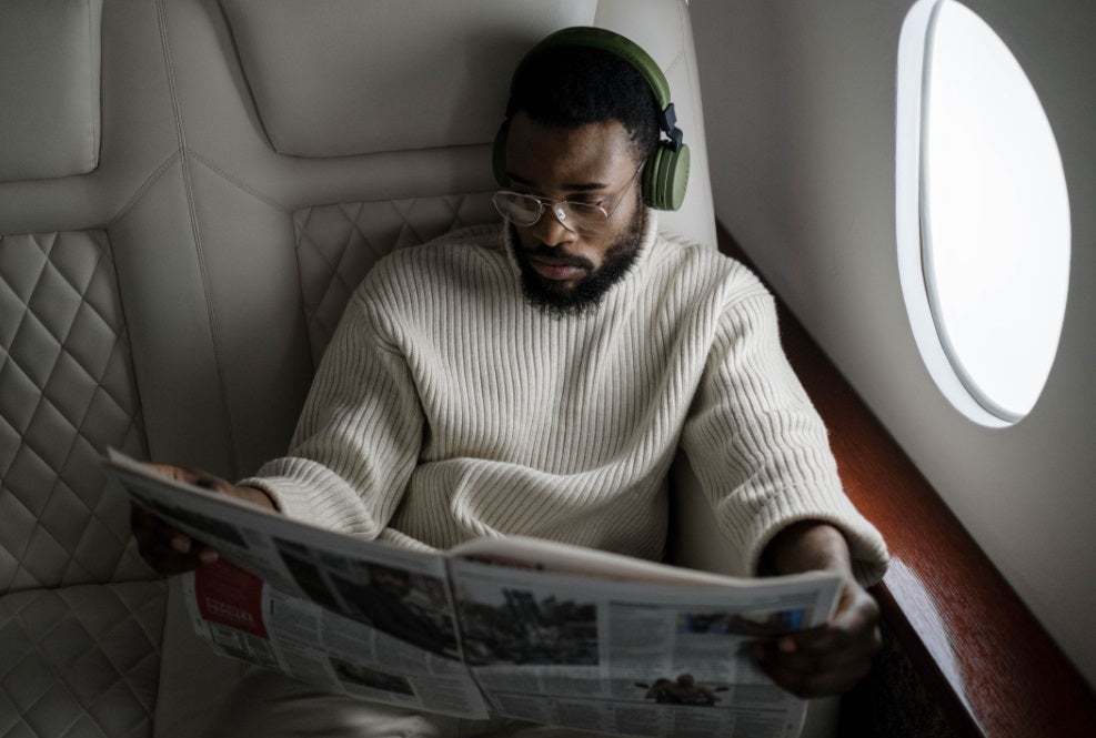 Traveler reading newspaper on plane