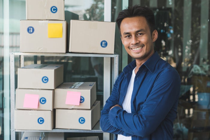 Concept modern new entrepreneur. E-commerce business owner calling to supplier to confirm order and reviewing checklist of customer address before sent box of product by parcel post.