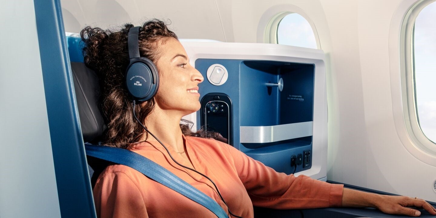 KLM business class female passenger with headphones