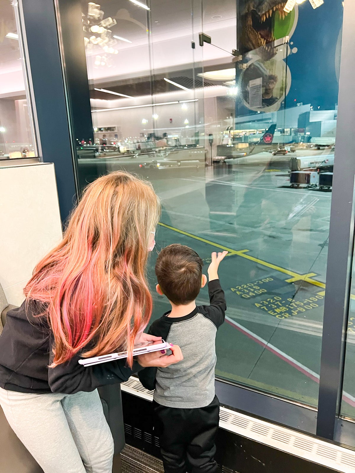 Kids looking at plane at the Admirals Club at Boston Logan International Airport