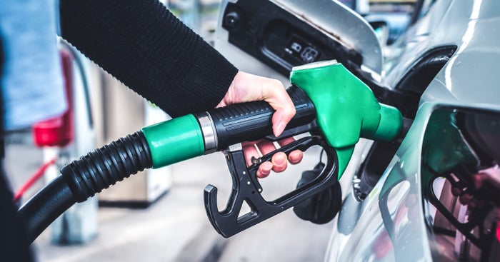 Person pumping gas green pump