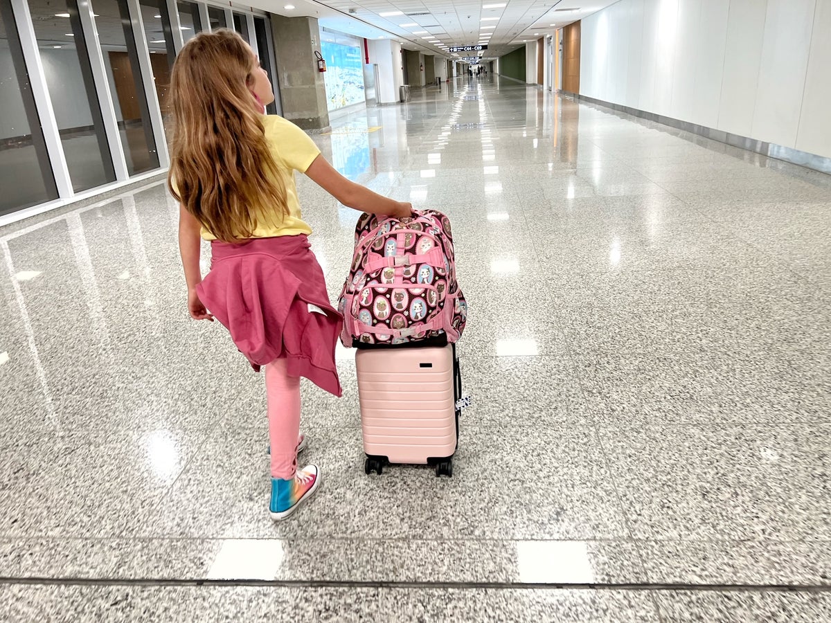 Girl walking through airport with Away bag in Rio de Janeiro airport GIG