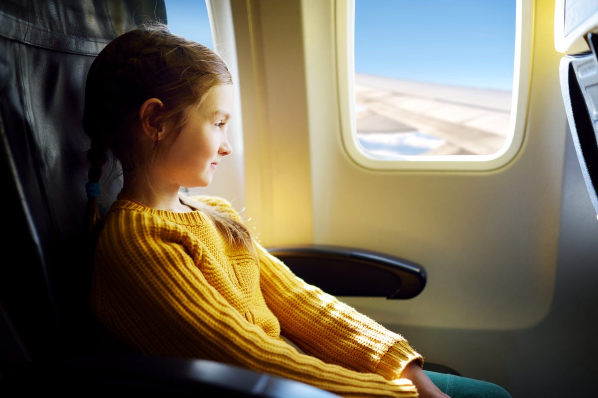 Girl looking out of window on airplane