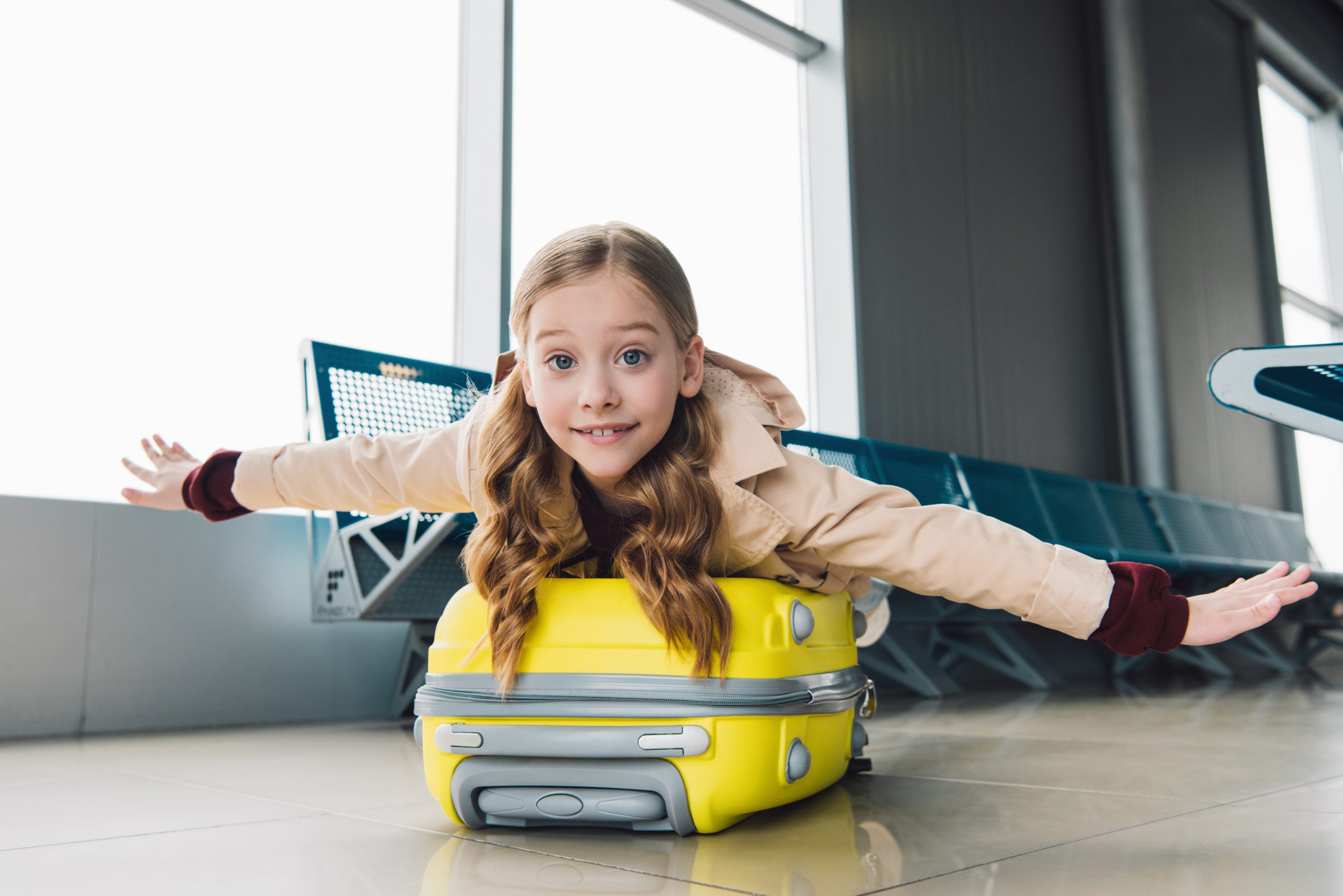 Girl on luggage at airport