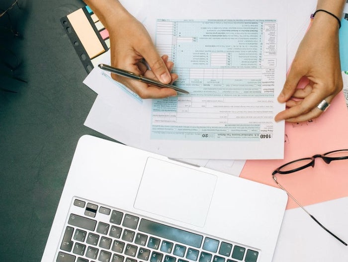 Paying Taxes overhead view of someone filling out tax forms