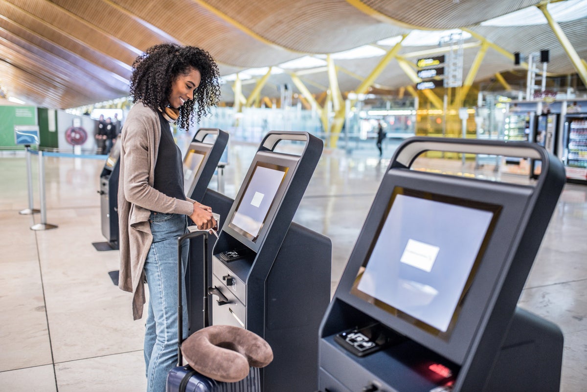 Woman checking in at airport kiosk