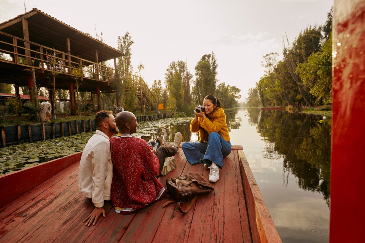 Woman takes picture of 2 men while on boat tour