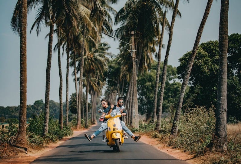 Couple on motorcycle with palm trees