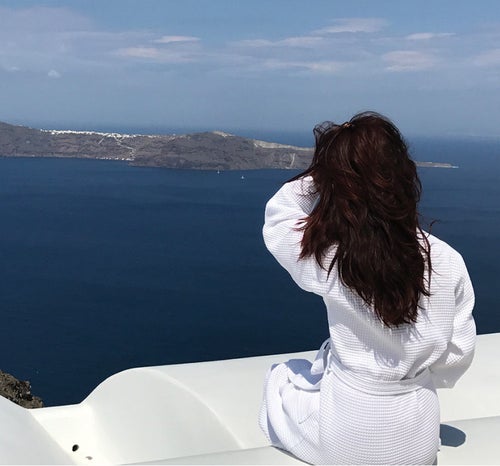 Photo of a woman relaxing atop of a scenic view of the ocean