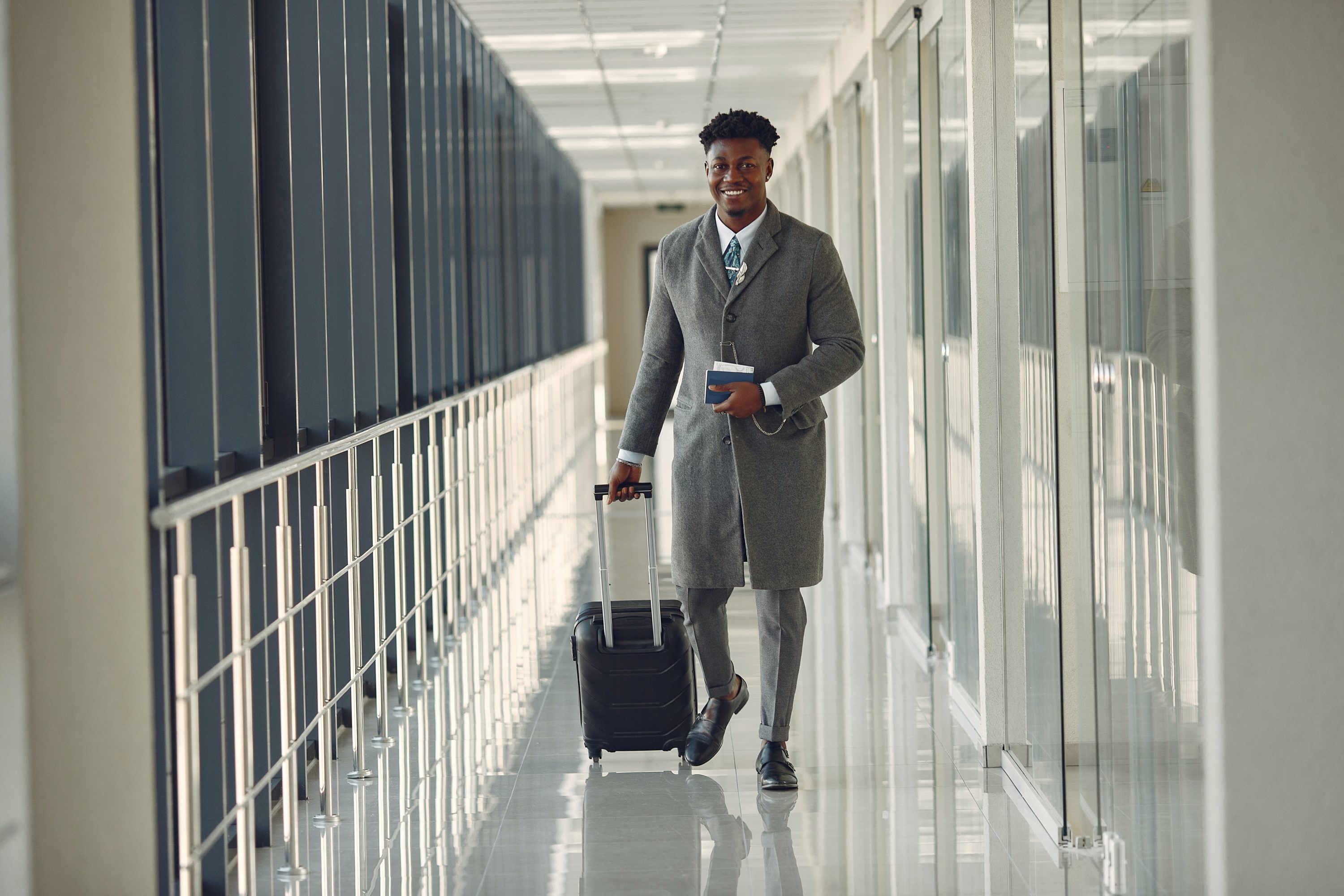 Businessman walking through airport with luggage