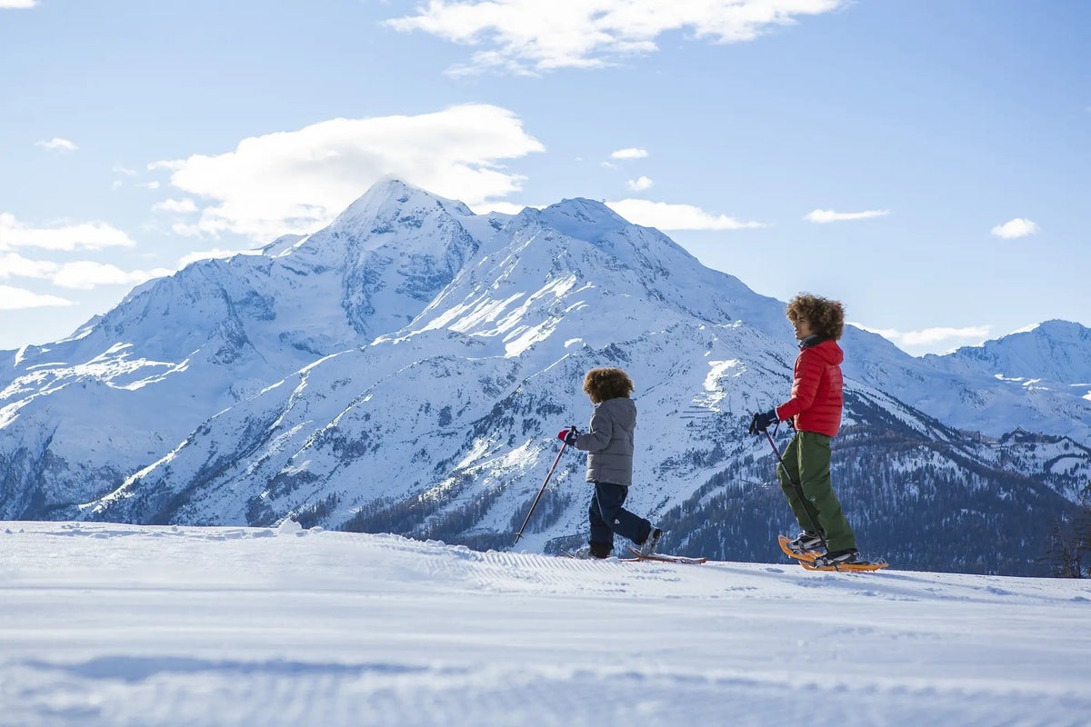 Two children snowshoeing on top of a mountain at Club Med Serre-Chevalier