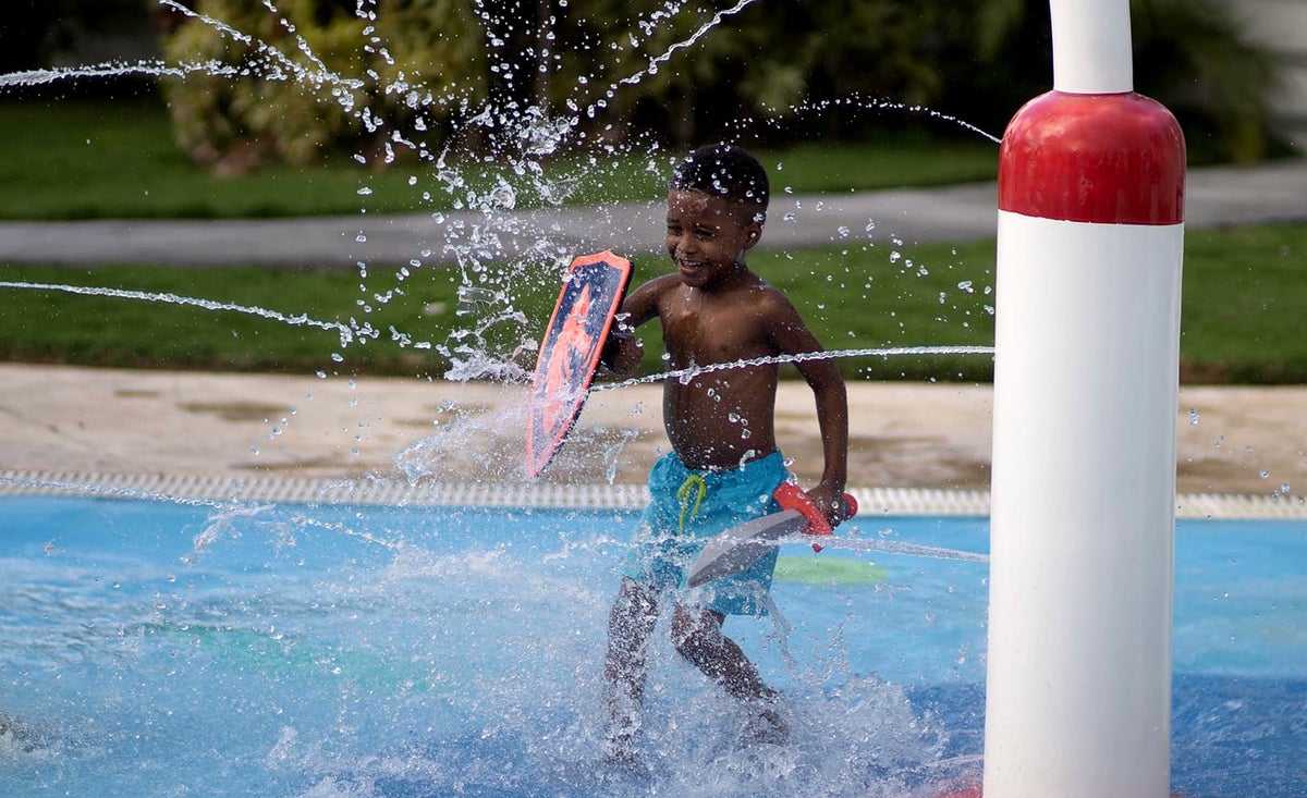 Boy enjoys the water park with a toy sword and shield at Moon Palace Jamaica