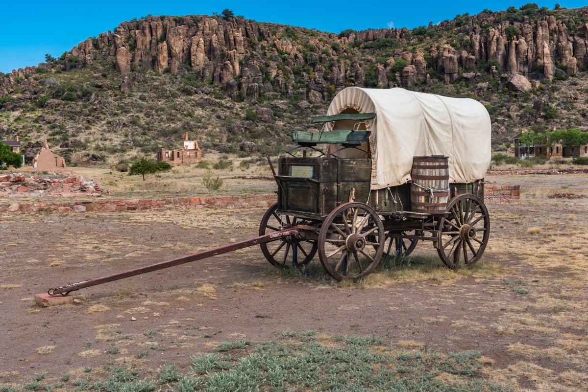 A Covered Wagon with a mountain in the background.