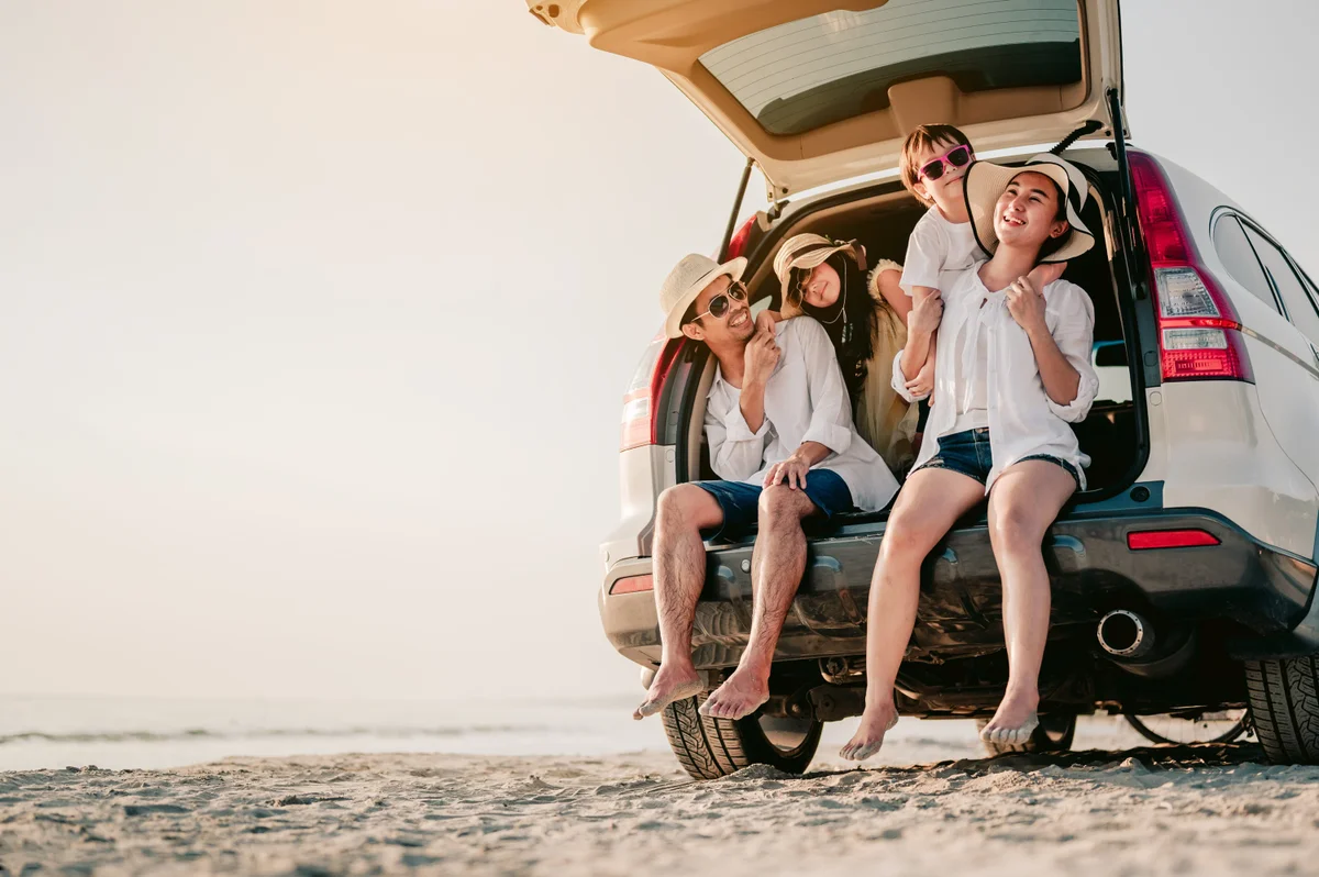 Family sitting in trunk of car