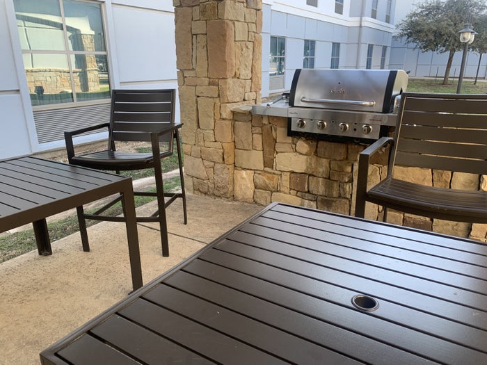 Outdoor seating area with a grill at Homewood Suites Austin Round Rock