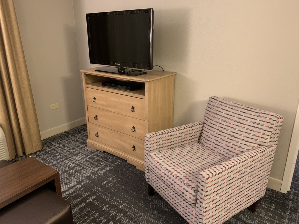 TV and chair in the guestroom at Homewood Suites Austin Round Rock