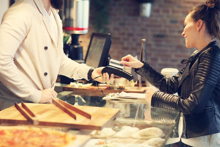 Woman paying by credit card in a restaurant Woman paying by credit card in a restaurant
