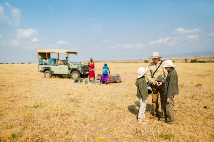 Family of father and kids on African safari vacation enjoying bush breakfast. Family of father and kids on African safari vacation enjoying bush breakfast.