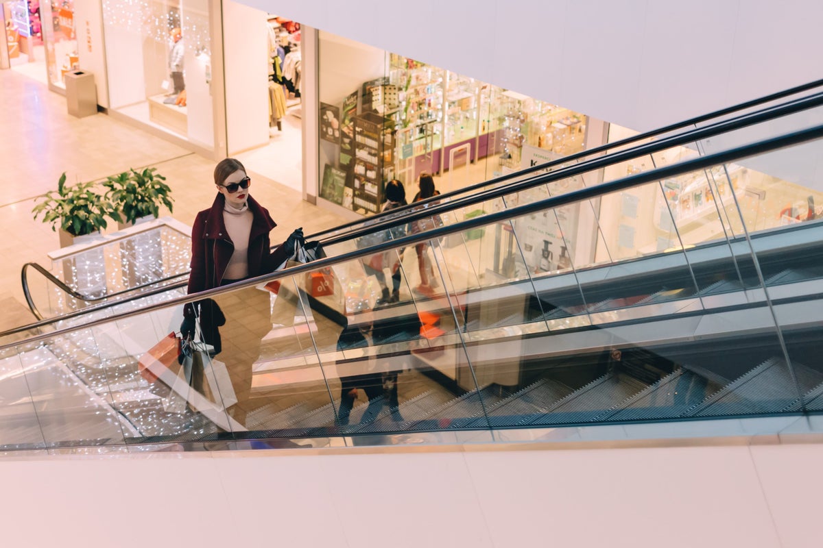 Woman with shopping bags walking in mall escalator