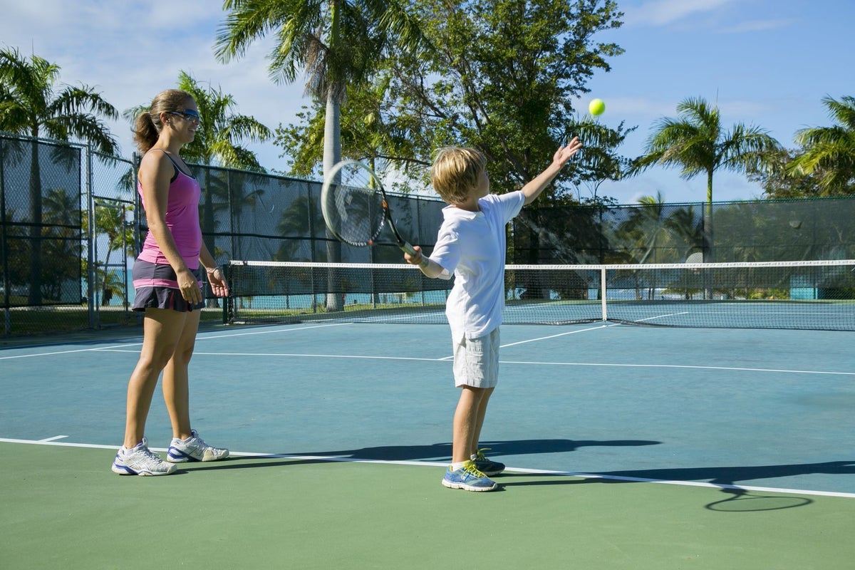 A mom and son play tennis at The Buccaneer Beach and Golf Resort.
