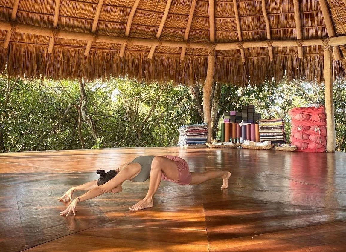 A persona doing yoga in an outdoor yoga shala