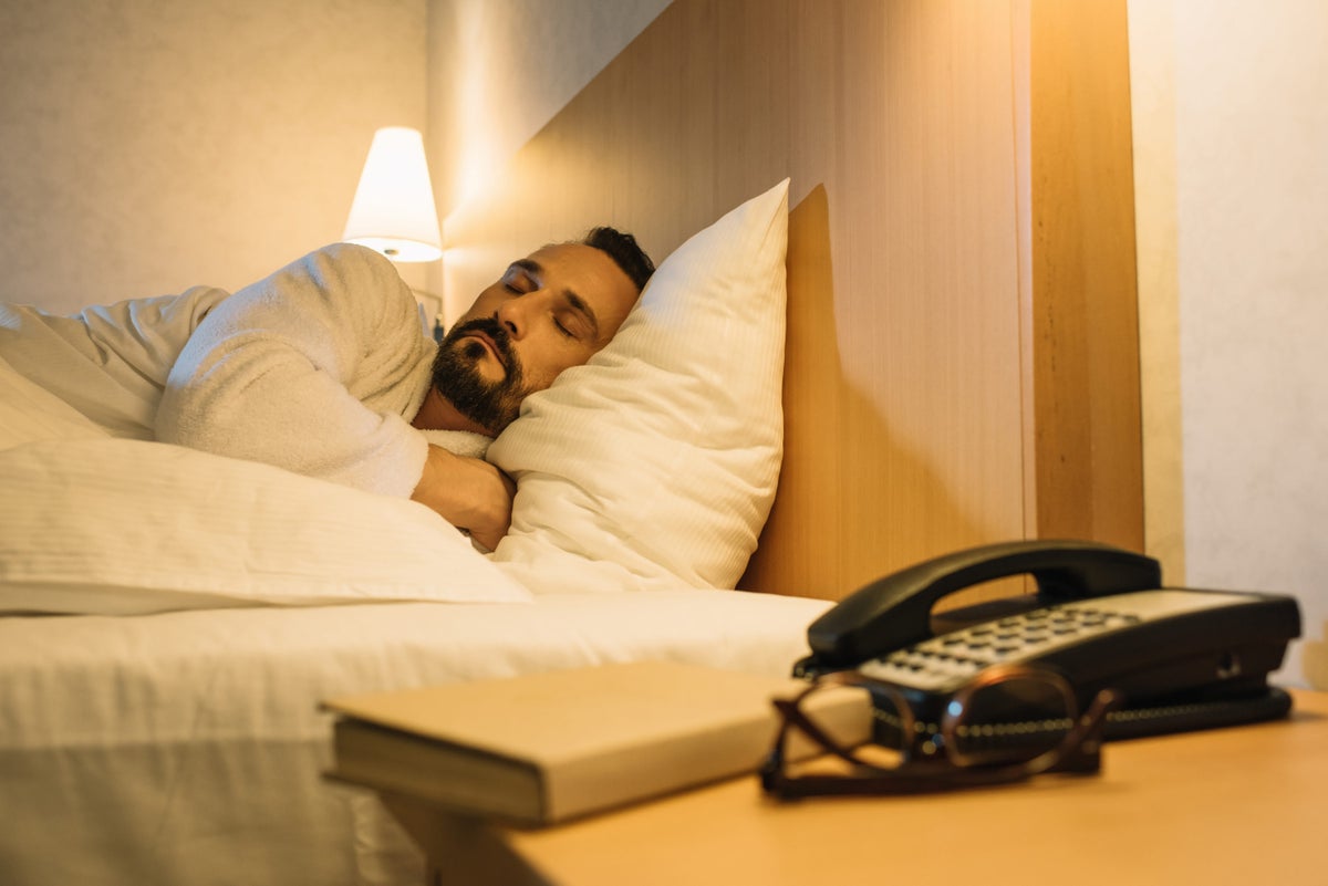 Man in bathrobe sleeping in hotel room