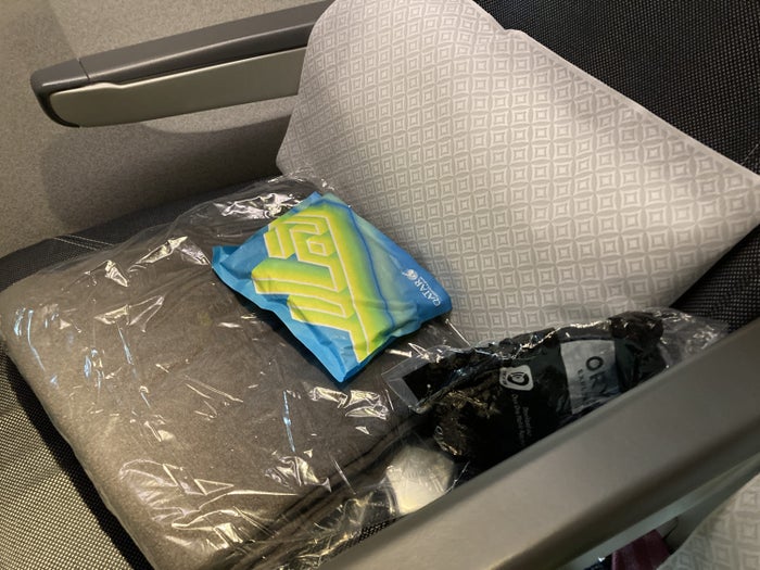 Qatar Airways 777 DOH DFW economy pillow blanket amenity headphones Qatar Airways 777 DOH DFW economy pillow blanket amenity headphones