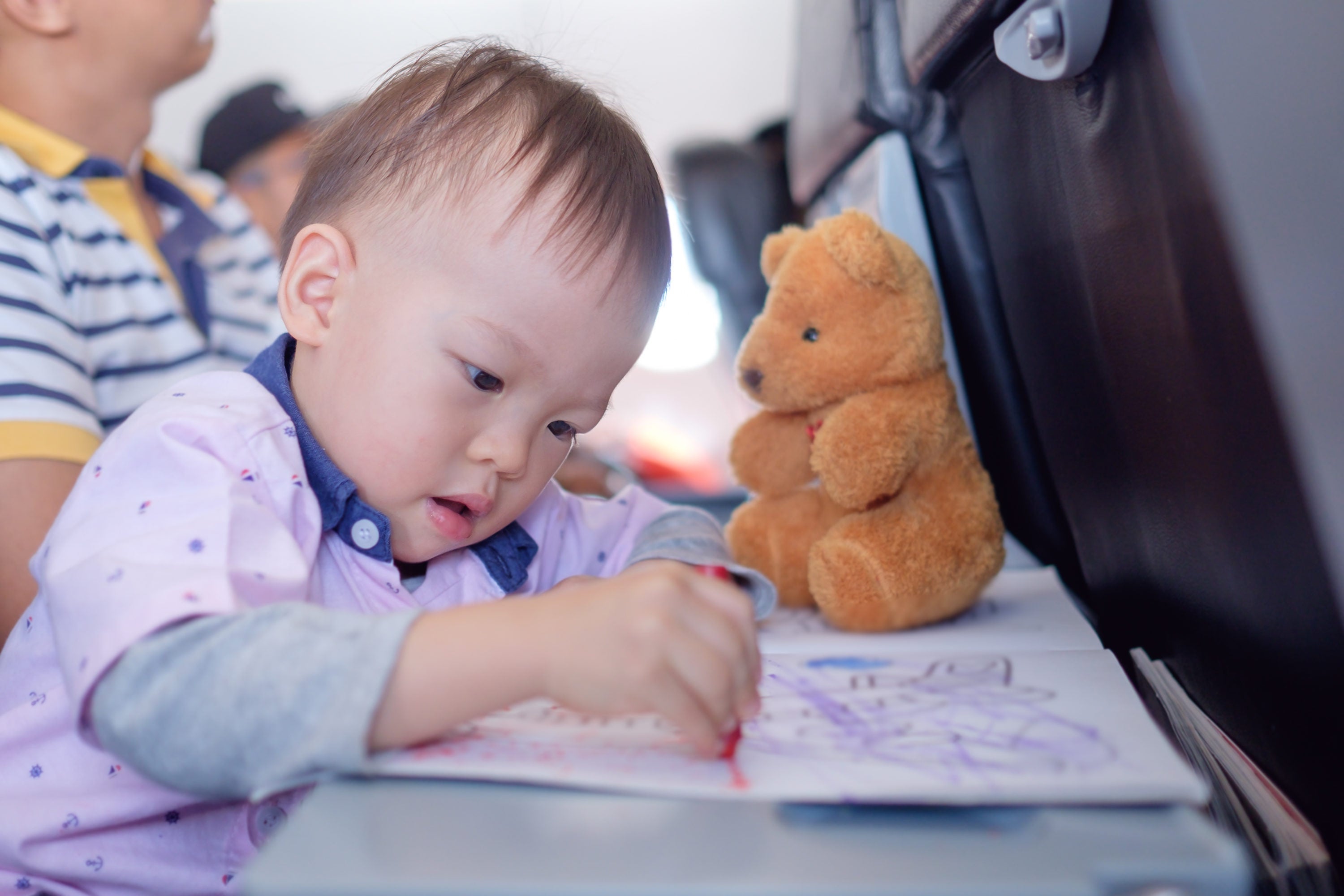 Toddler coloring on plane