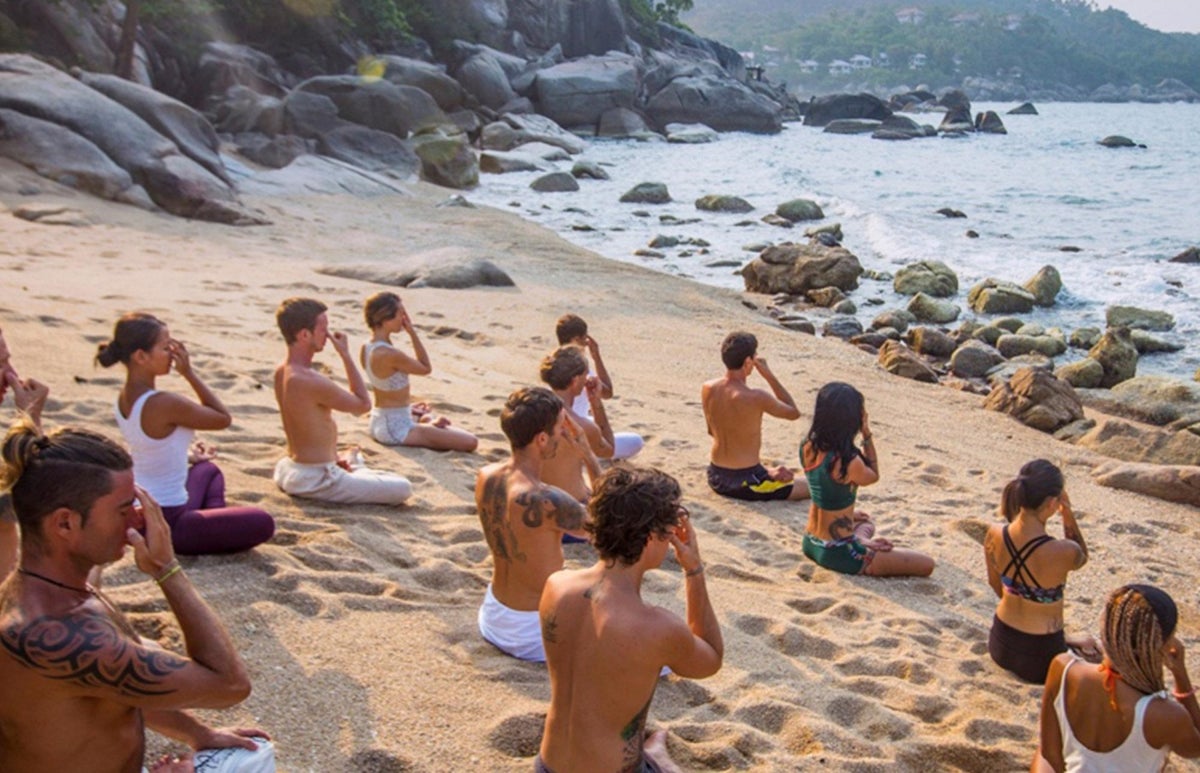 A group of people doing yoga on a beautiful beach