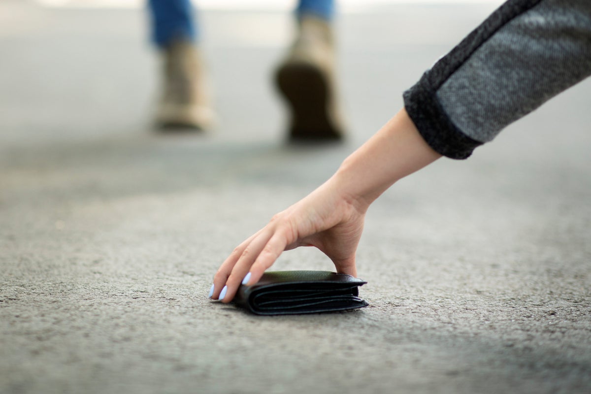 Woman picking up dropped wallet