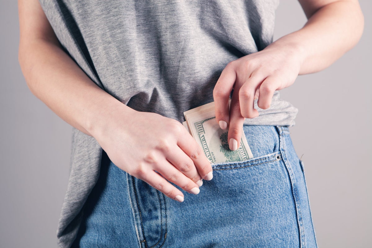 Woman putting money in her pocket