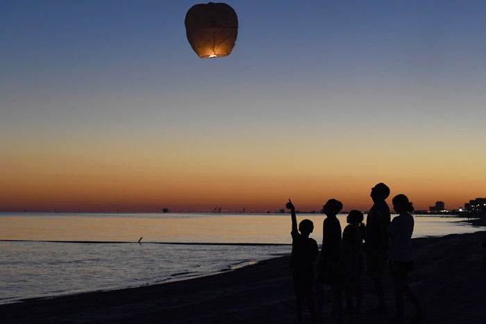 Family Launching Paper Lantern Over Water Family Launching Paper Lantern Over Water