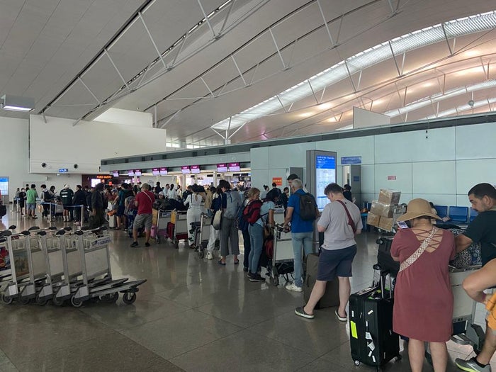 Man with backpack at airport departure board Ho Chi Minh Qatar Airways checked bags