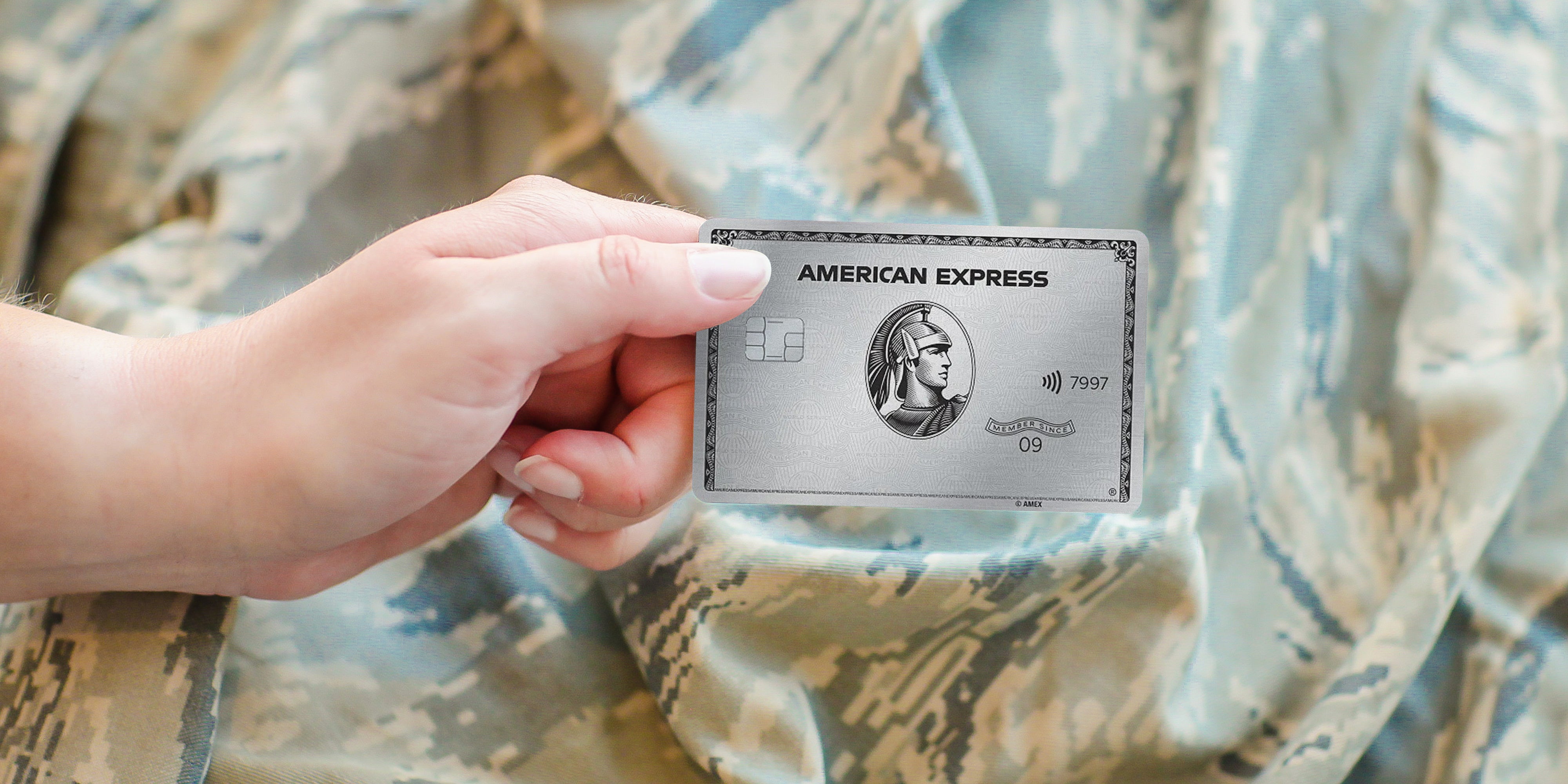 amex platinum card held infront military clothing