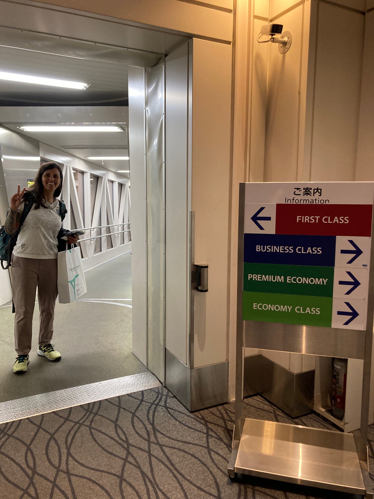 Woman near boarding signs indicating she is heading to the first-class cabin.