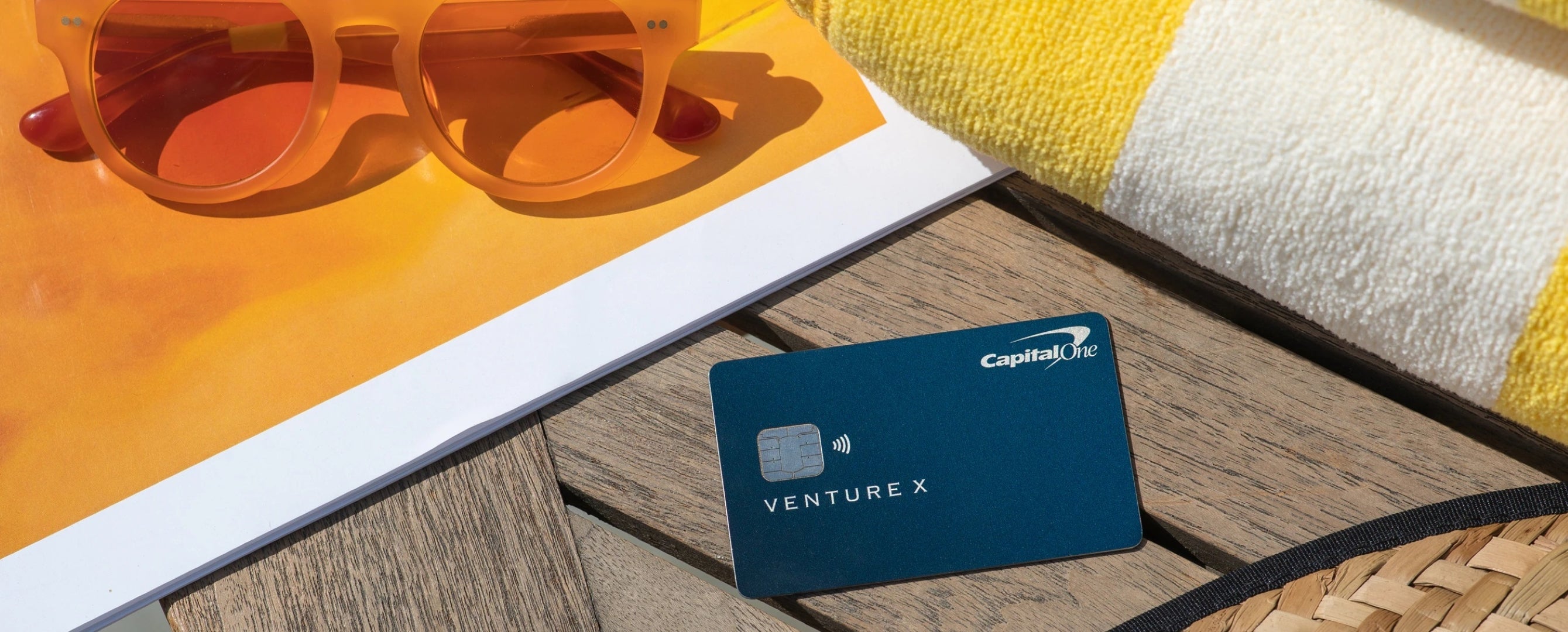 Capital One Venture X with sunglasses and towel