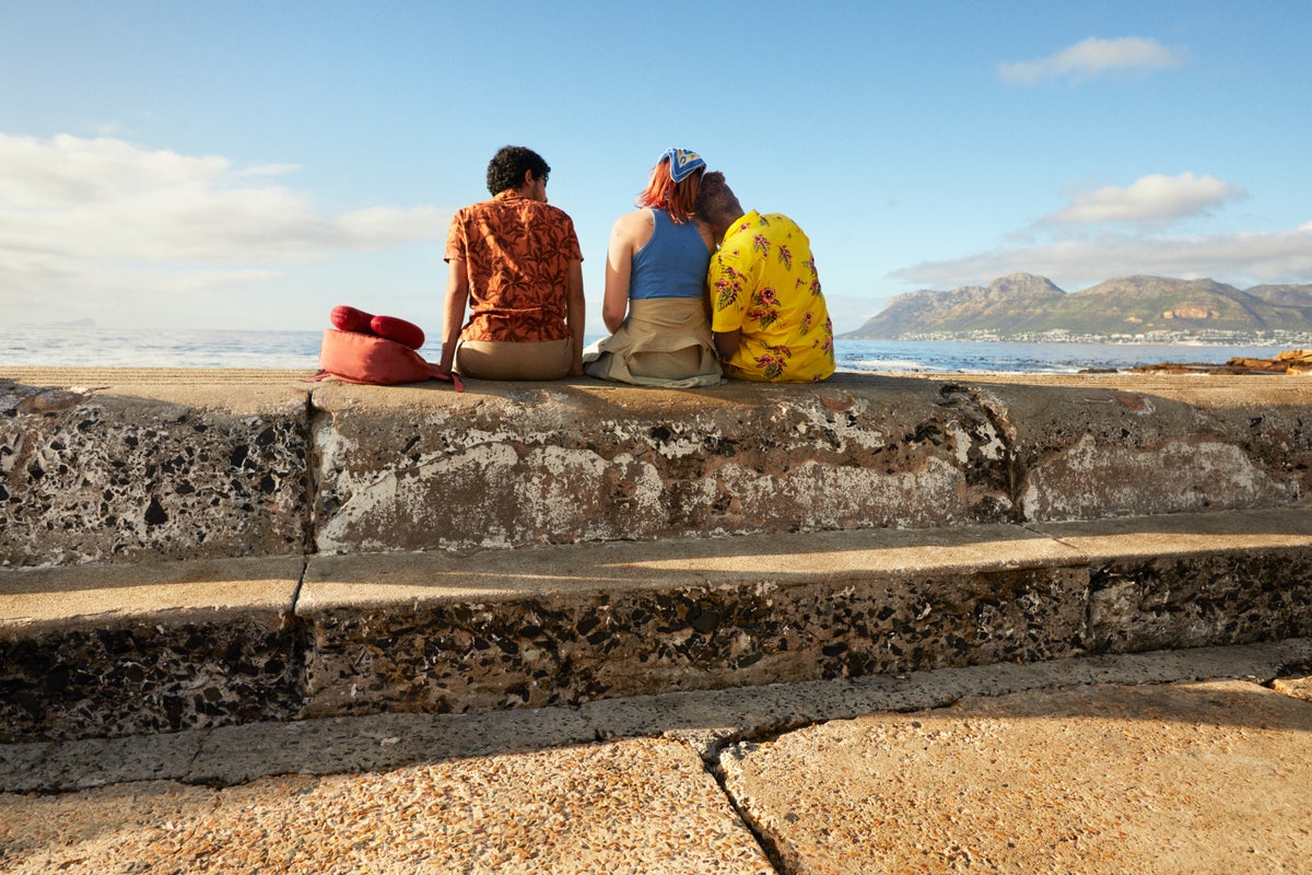 Friends on ocean wall facing away