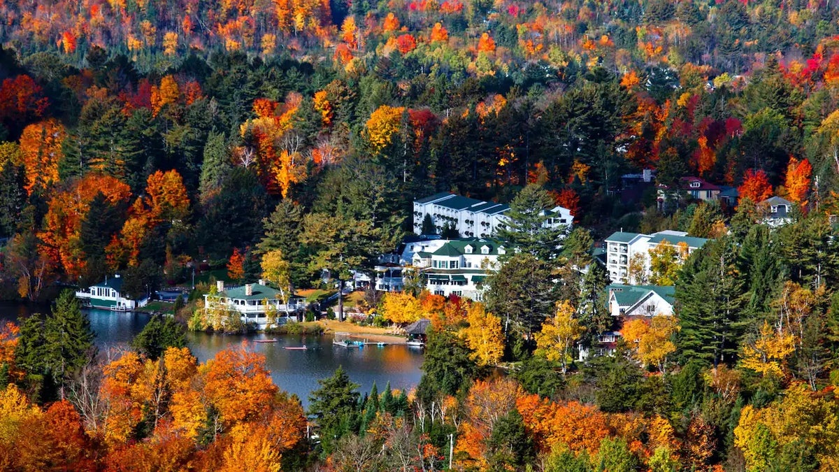 Aerial view of Mirror Lake Inn Resort and Spa on Lake Placid, New York with fall foliage surrounding the buildings