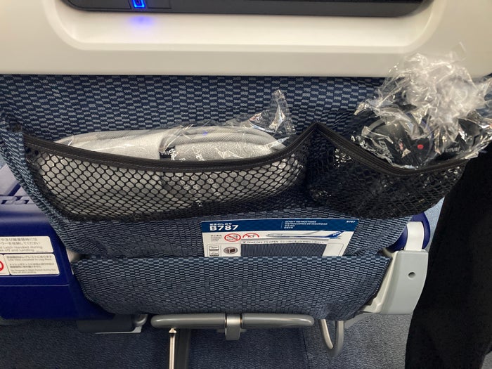 ANA premium economy Boeing 787 seat pockets with headphones and slippers ANA premium economy Boeing 787 seat pockets with headphones and slippers