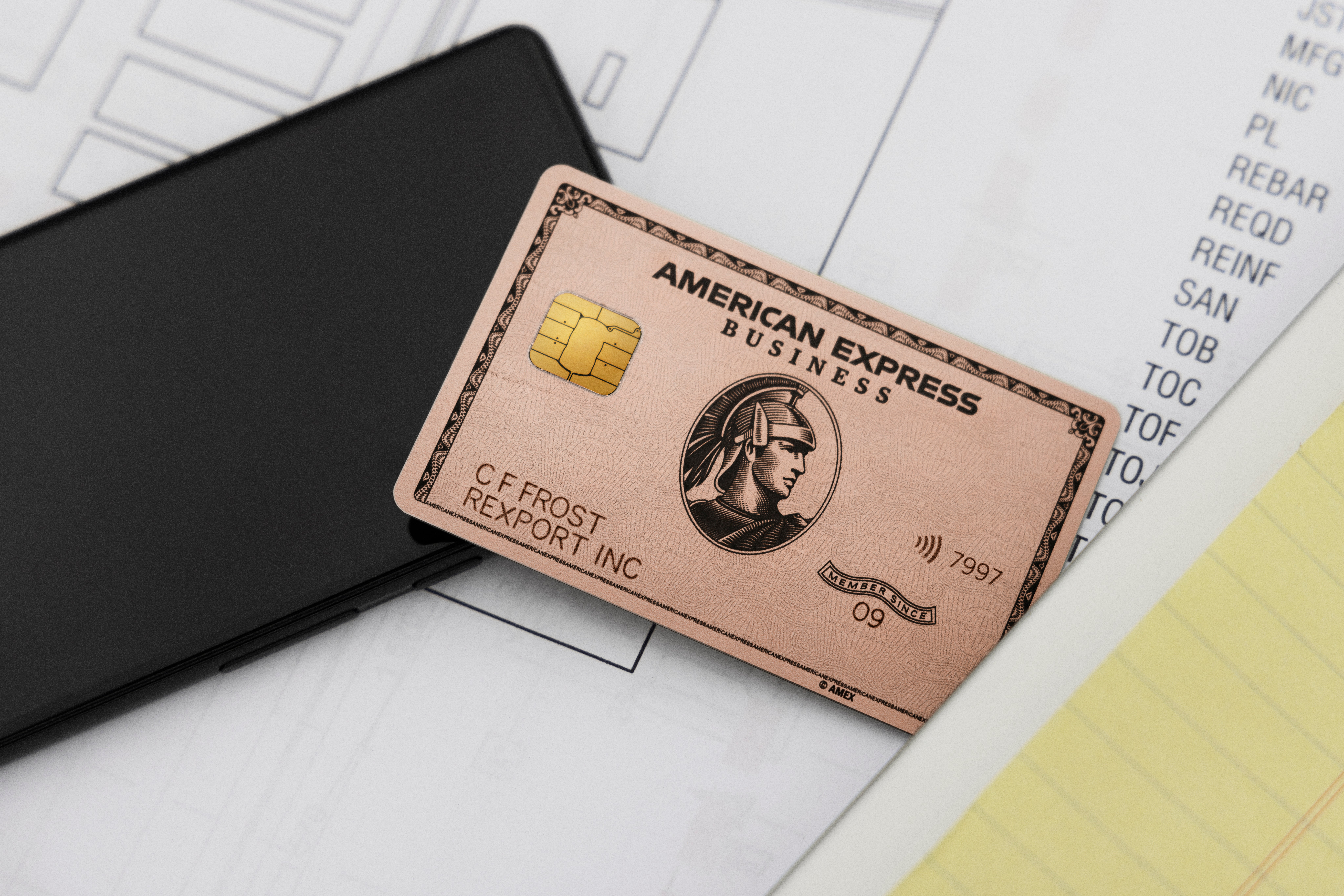 Amex Business Rose Gold Card on top of paperwork