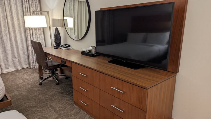 Hilton Pensacola Beach guestroom dresser with TV and desk Hilton Pensacola Beach guestroom dresser with TV and desk